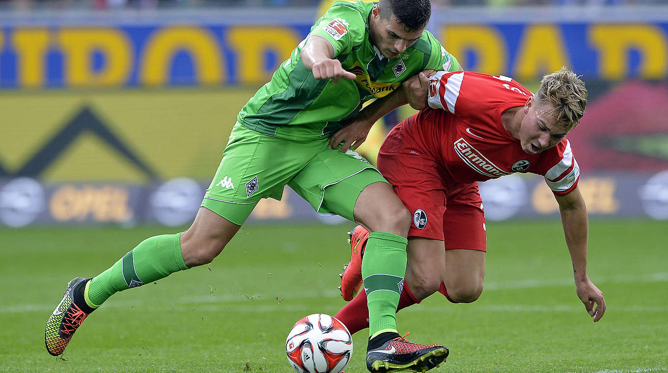 Challenges Granit Xhaka (L) of Borussia Moenchengladbach: Felix Klaus © 2014 Getty Images