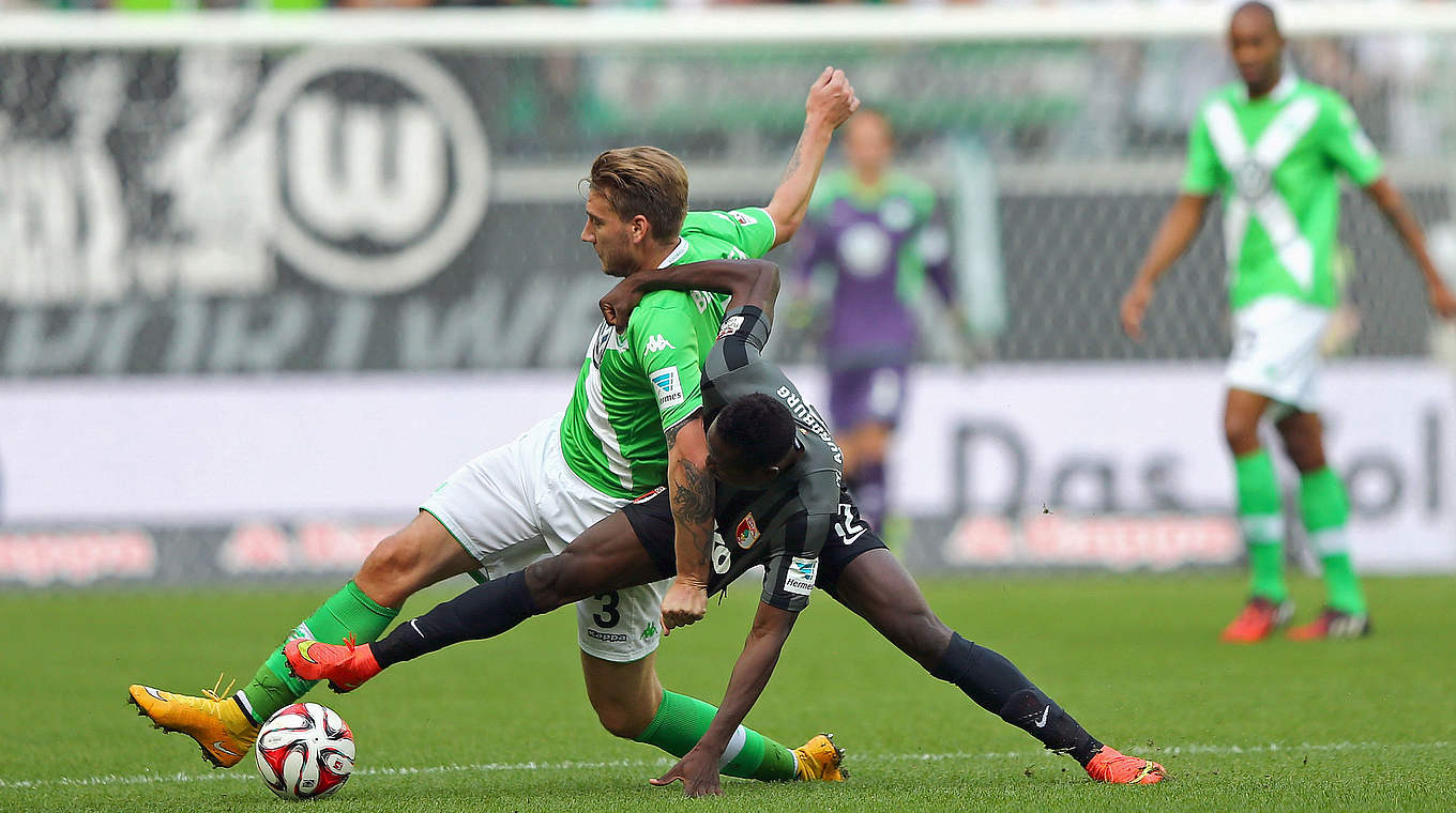 Intensive Begegnung: Bendtner (l.) im Zweikampf mit FCA-Verteidiger Baba © 2014 Getty Images