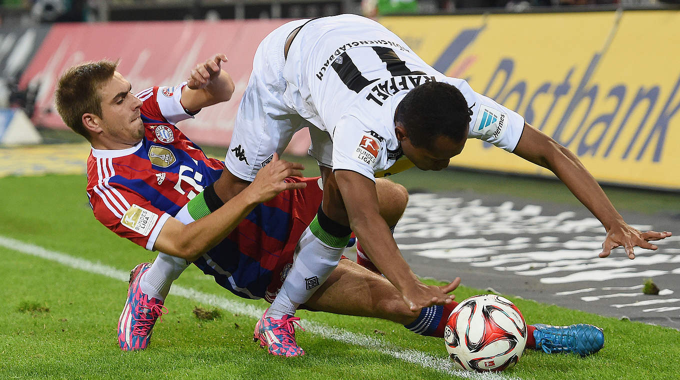 Es geht um jeden Zentimeter: Philipp Lahm (l.) im Duell mit Raffael © 2014 Getty Images