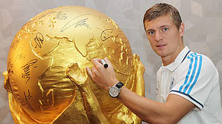 Zu versteigern: der riesige WM-Pokal mit der Unterschrift von Toni Kroos © United Charity