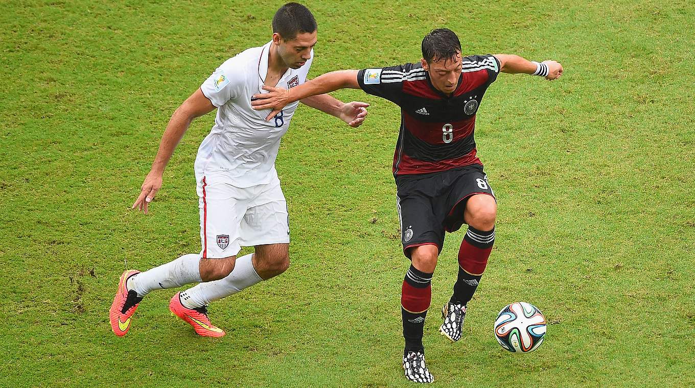 Mesut Özil hält in Recife den US-Amerikaner Clint Dempsey auf Distanz. © Getty Images