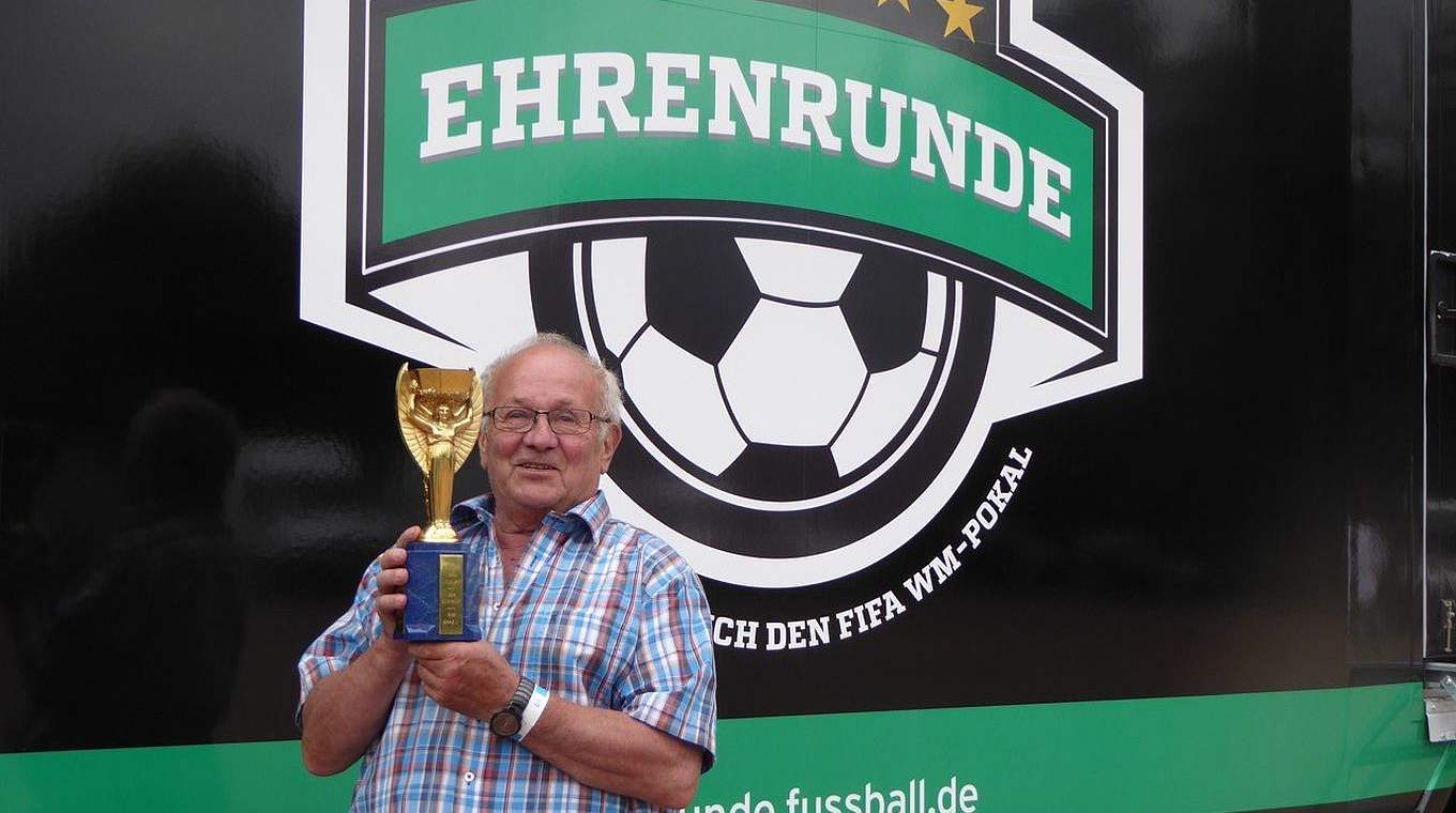 Ludwig Oswald mit seinem WM-Pokal vor den Trucks der Ehrenrunde © Barnhofer