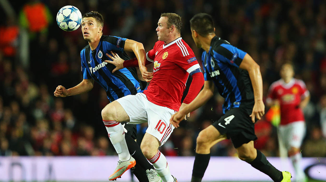 Man United star Wayne Rooney taking on two men.  © 2015 Getty Images