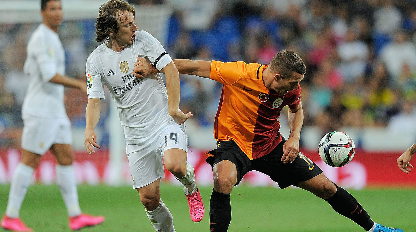 Podolski takes on Luka Modric in a competitive encounter © 2015 Getty Images