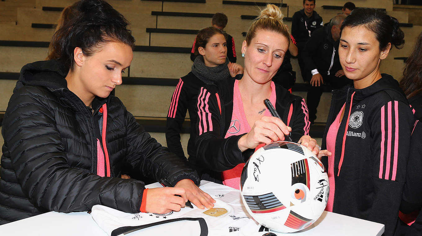 Besuch im Fußballmuseum: Mittag (M.) und Co. signieren einen Ball © 2015 Getty Images