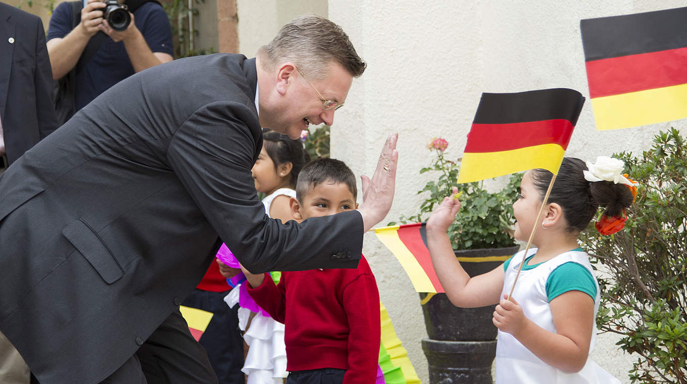 "Alemania Ra Ra Ra": Ein Mädchen aus der "Casa de Cuna" klatscht Reinhard Grindel ab  © GettyImages