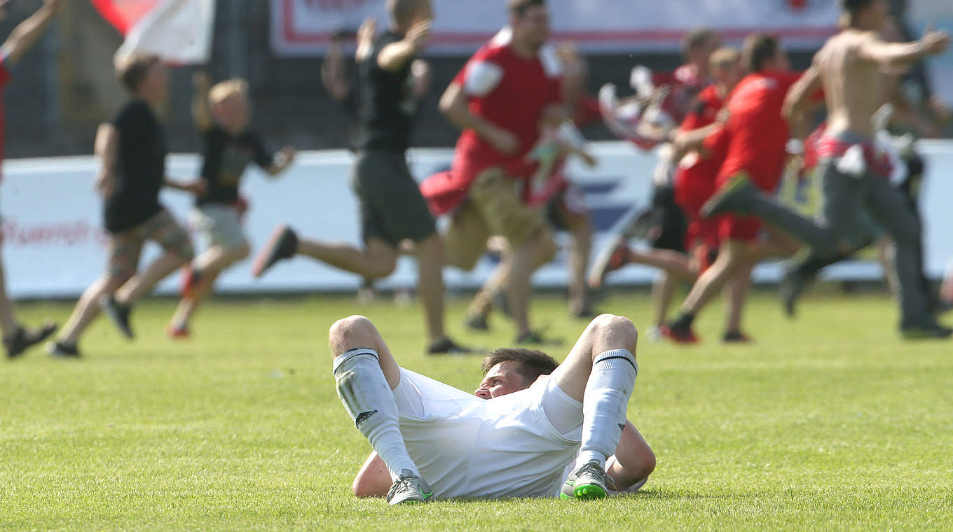 Jubel und Trauer liegen in der Relegation nah beieinander: Matthias Cuntz enttäuscht auf dem Rasen, während die Zwickauer Fans ausgelassen feiern. © 2016 Getty Images