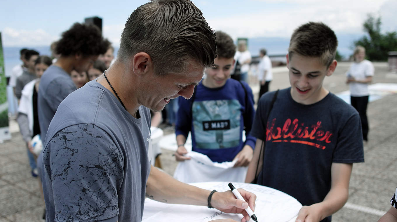 Schreiben fleißig Autogramme: die Spieler rund um Weltmeister Toni Kroos (l.) © DFB