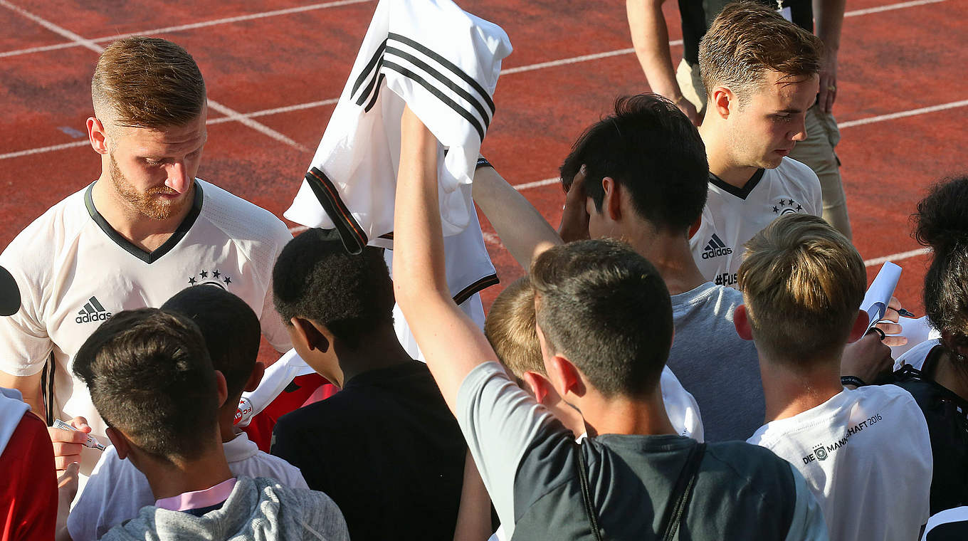 Autogramme inklusive: Shkodran Mustafi und Mario Götze (r.) versorgen die jungen Fans © Getty Images