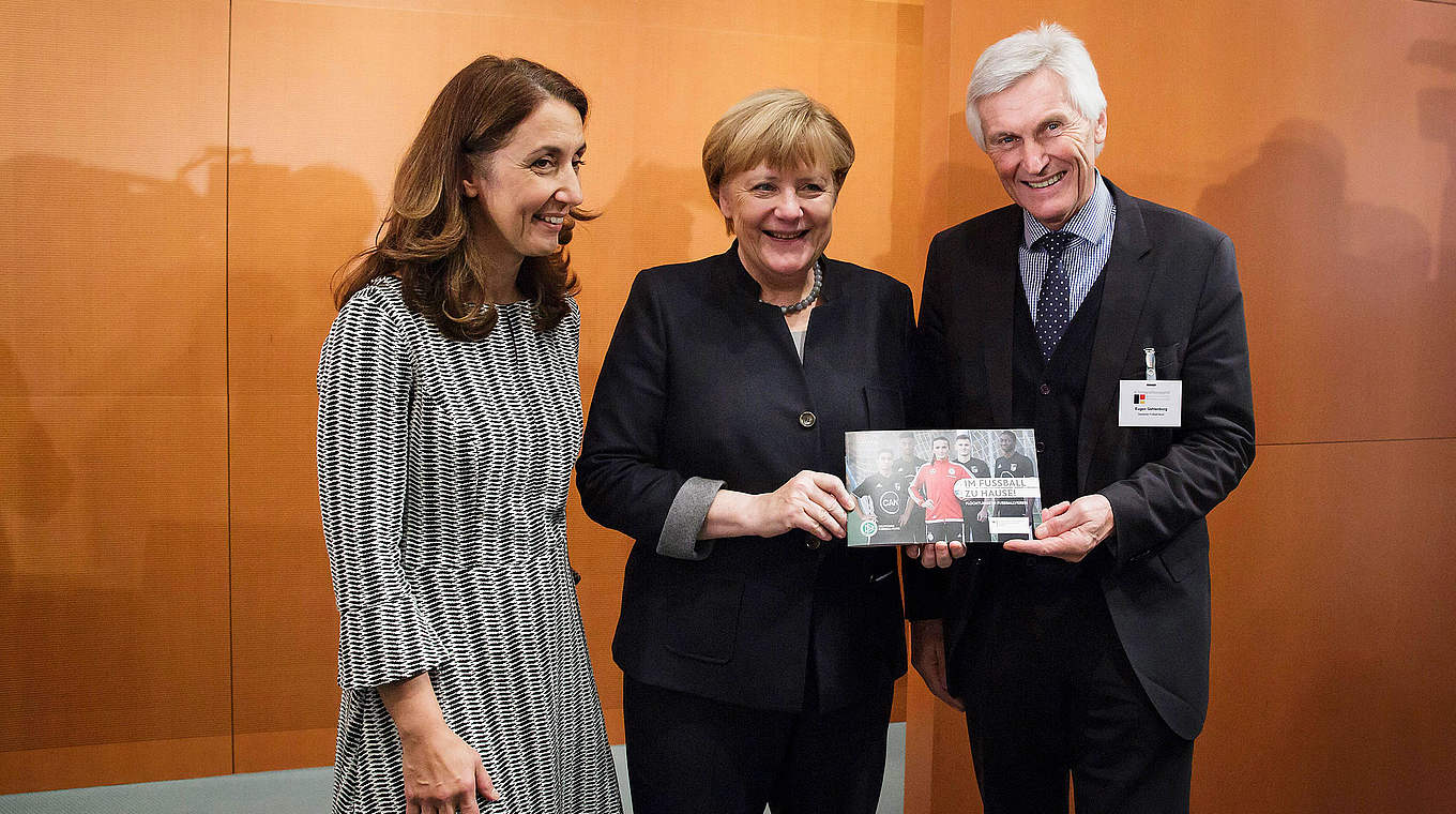 Stellt mit Merkel und Özoğuz (l.) die DFB-Flüchtlingsbroschüre vor: Gehlenborg © Bundesregierung/Steins
