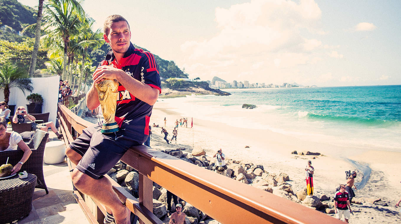 Mit WM-Pokal an der Copacabana: Lukas Podolski nach dem Titelgewinn 2014 in Rio © Paul Ripke