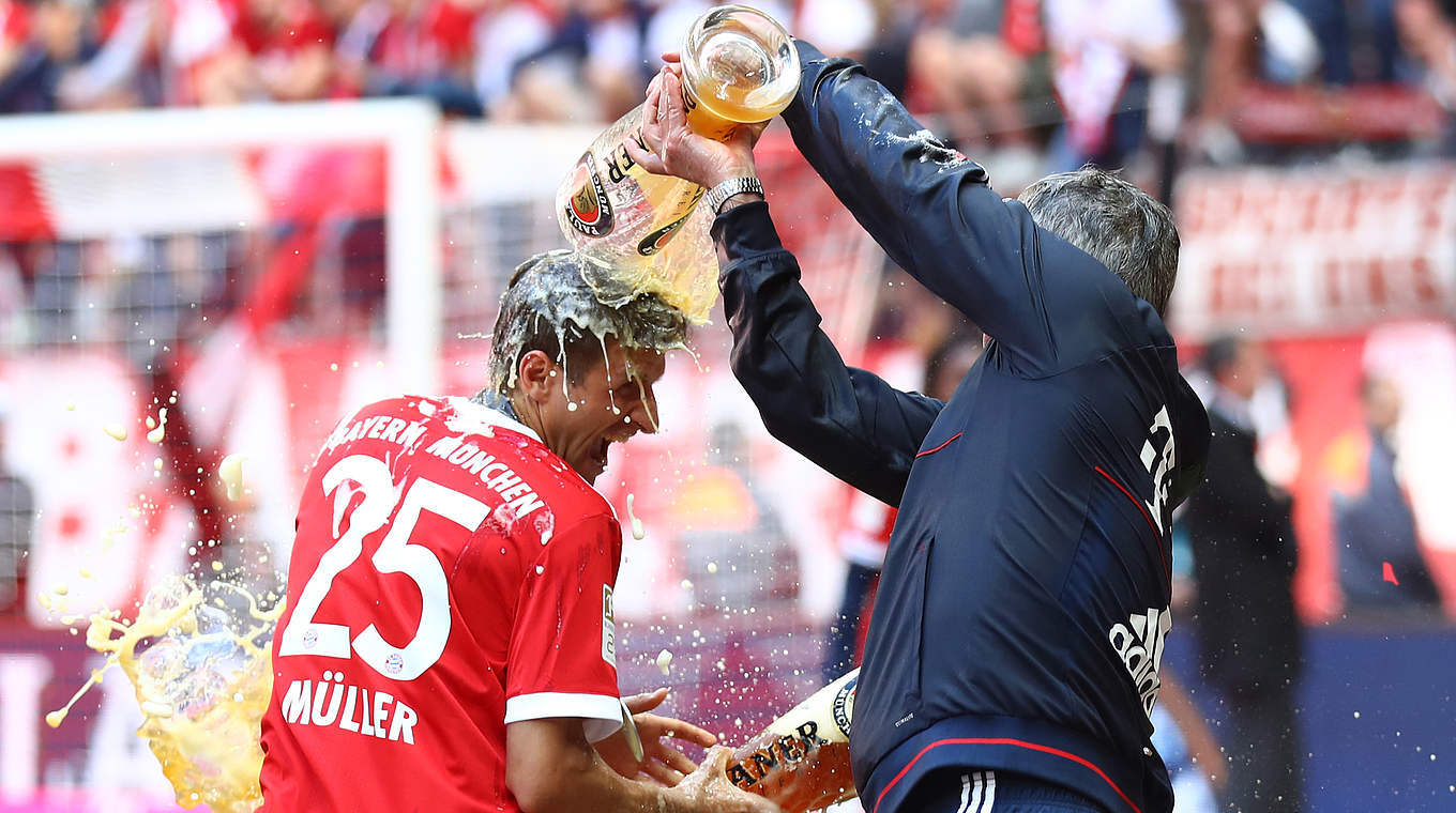 Bierdusche: Bayerns Trainer Carlo Ancelotti (r.) übergießt Thomas Müller mit Gerstensaft  © 2017 Getty Images