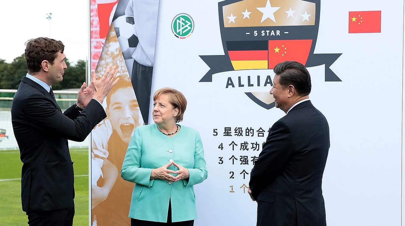 DFB-Generalsekretär Dr. Friedrich Curtius erklärt Bundeskanzlerin Angela Merkel und Chinas Staatspräsident Xi Jinping die "5-Star-Alliance". © Getty Images