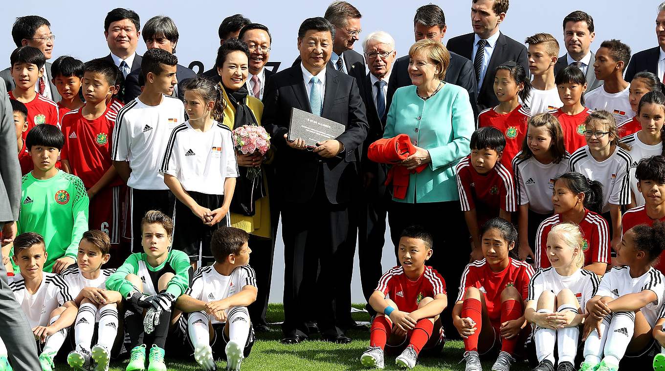Chinas Staatspräsident Xi Jinping und Bundeskanzlerin Angela Merkel erhielten in Berlin Geschenke von den U 12-Teams. © Getty Images