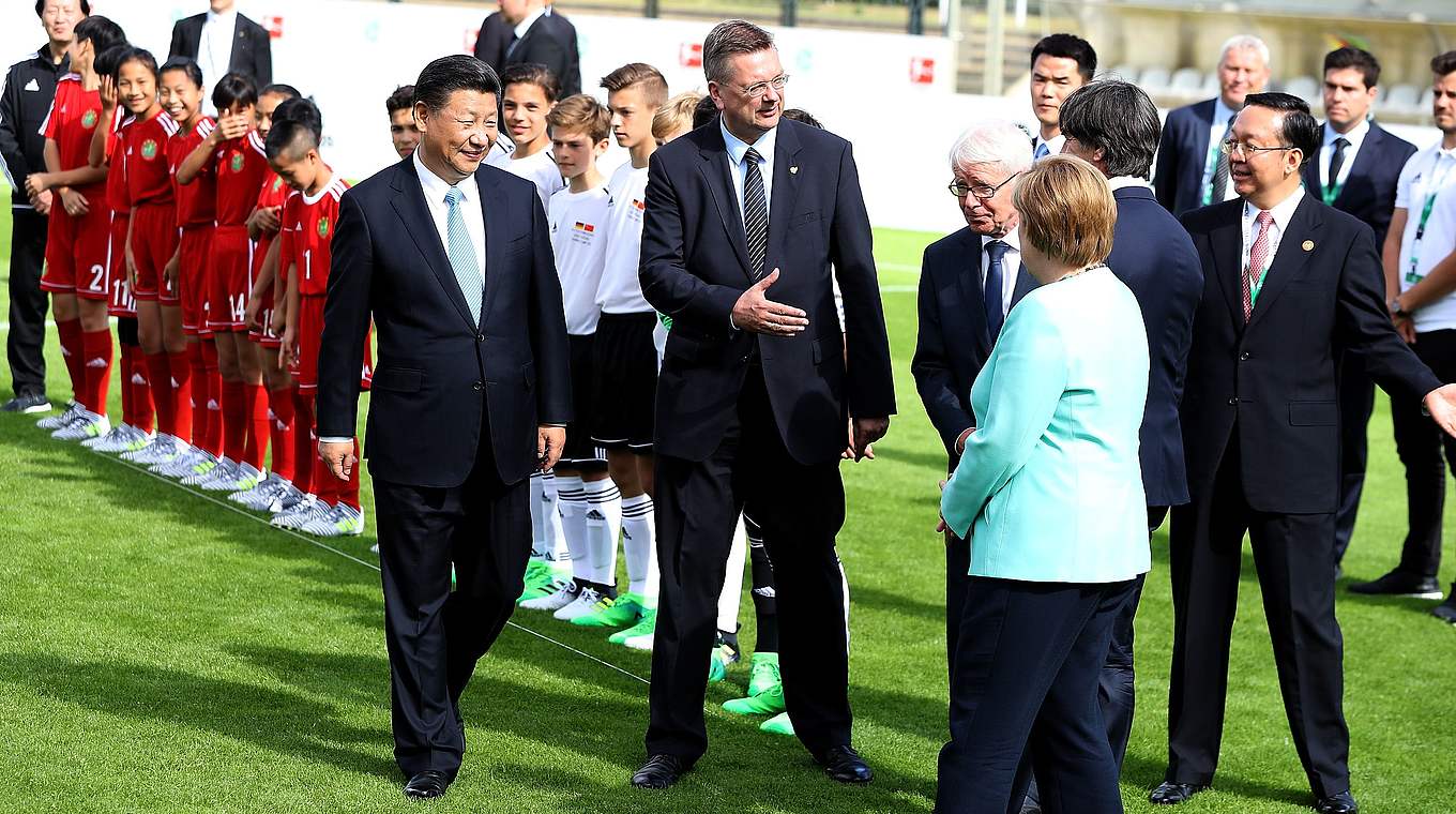 Grindel, Rauball, Merkel und Xi im Stadion auf dem Wurfplatz in Berlin.  © Getty Images