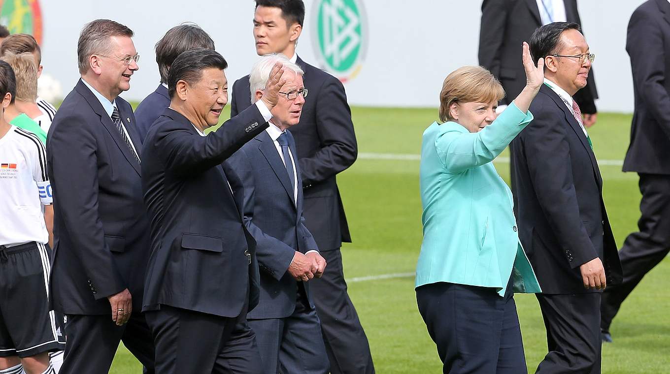 Bundeskanzlerin Angela Merkel und Chinas Staatspräsident Xi Jinping winken dem Publikum.  © Getty Images