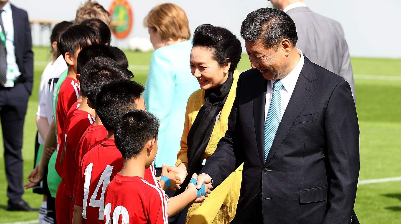 Chinas Staatspräsident Xi Jinping und Gemahlin gehen durchs Spieler-Spalier. © Getty Images