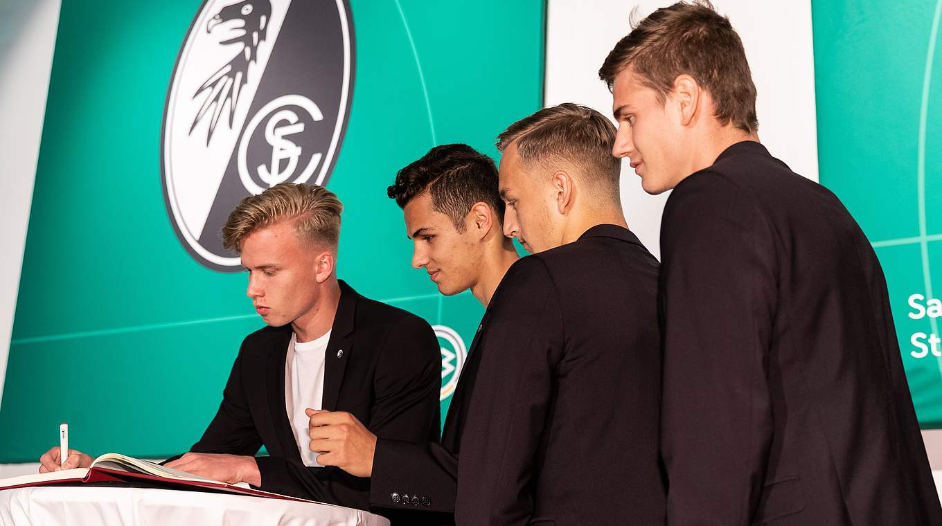 Die Freiburger Spieler unterschreiben im Goldenen Buch.  © Getty Images