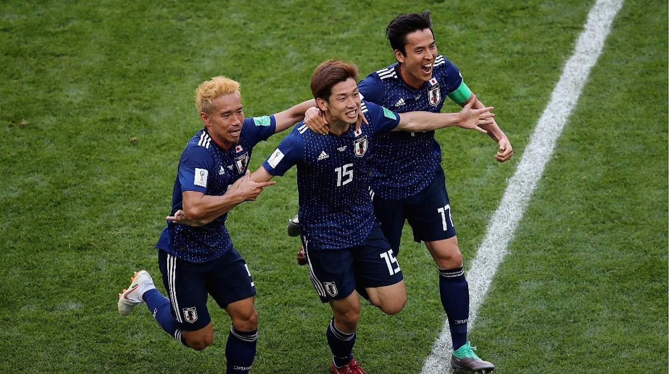Japans Yuto Nagatomo and Makoto Hasebe mit dem Torschützen Yuya Oskao in der Mitte beim 2:1 gegen Kolumbien.  © Getty Images