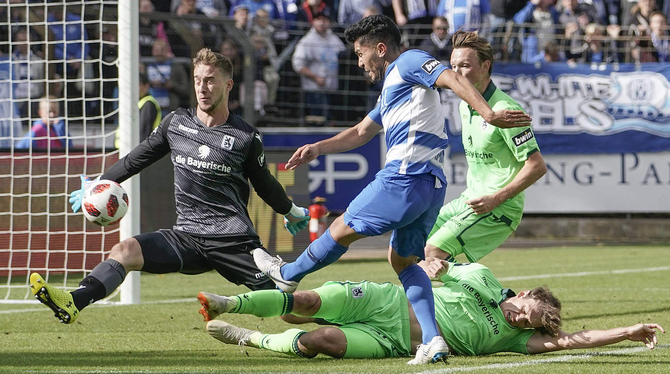 1860-Keeper Hiller (l.) geschlagen: Amin (blau-weißes Trikot) mit dem Tor des Tages © imago/Werner Scholz