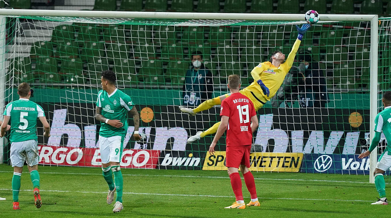 Werder's Jiri Pavlenka stretches to tip Will Orban's header onto the bar.  © imago
