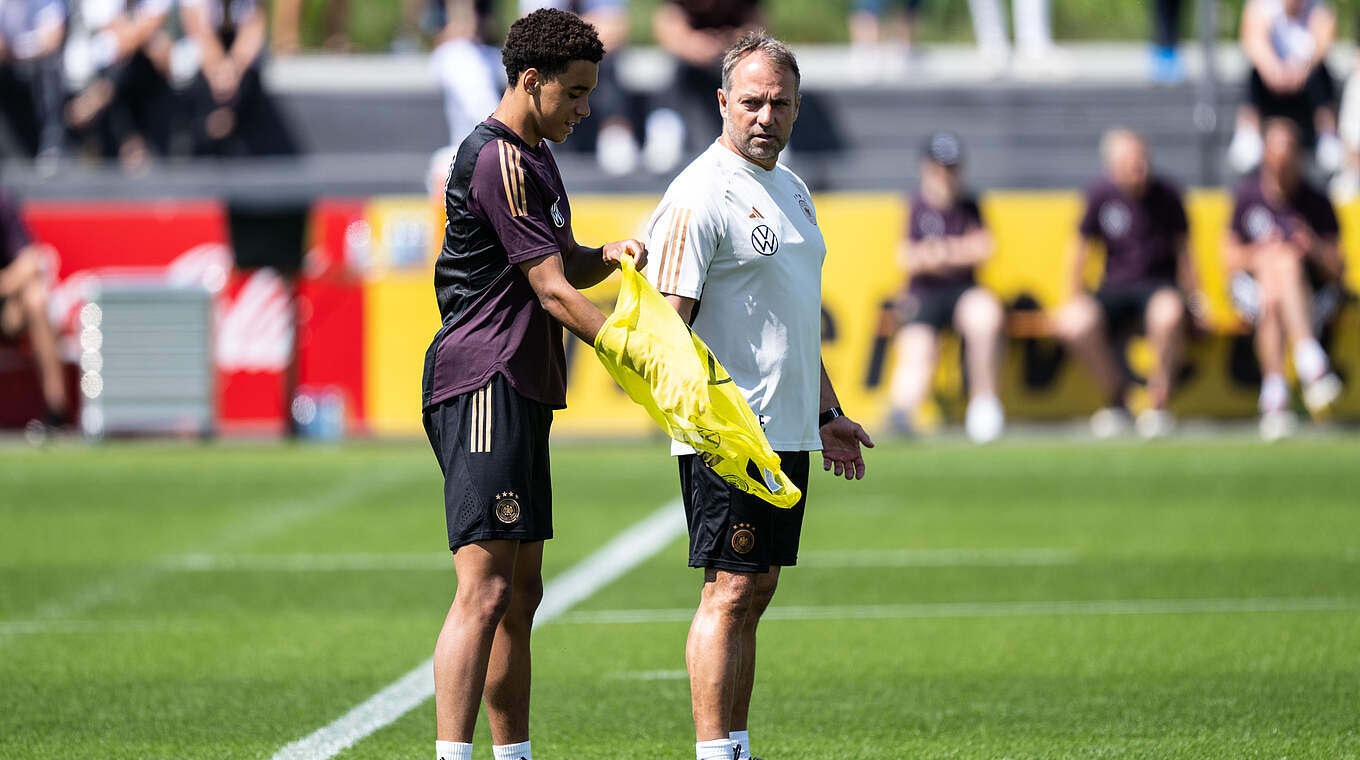 Jamal Musiala (l.) und Bundestrainer Hansi Flick (r.) © GES/DFB