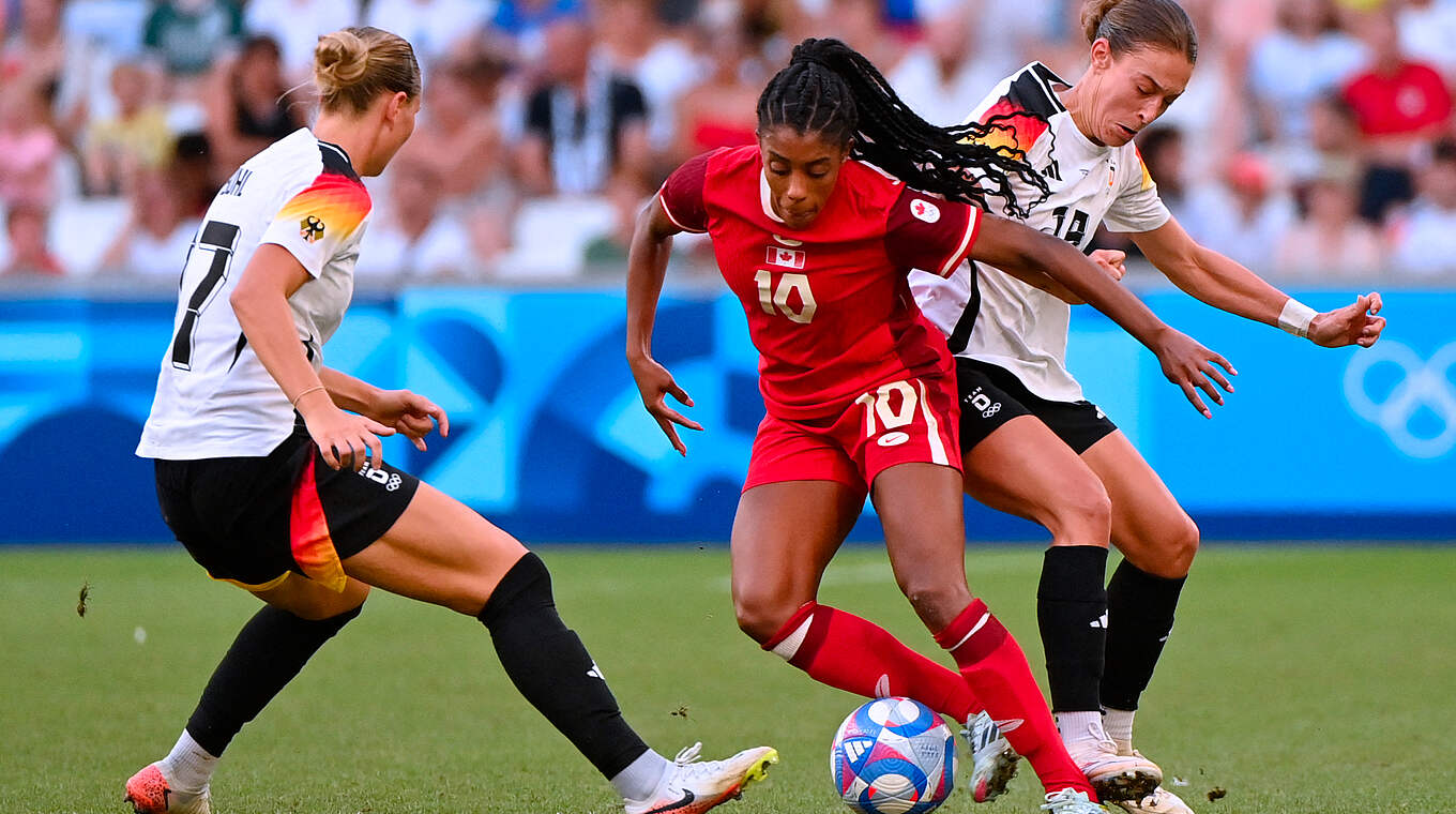 Ashley Lawrence (m.) takes on Rauch (r.) and Popp (l.).  © Getty Images