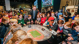 Bestaunen die Exponate des Fußballmuseums: Grindel und die begeisterten Kinder © Deutsches Fußballmuseum