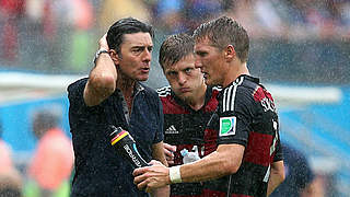 Beratungsgespräch im Regen: Joachim Löw, Toni Kroos und Bastian Schweinsteiger (v.l.) © Bongarts/GettyImages