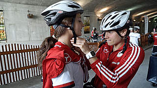 Sicherheit geht vor: Annike Krahn (r.) fixiert Sara Däbritz' Fahrradhelm © DFB