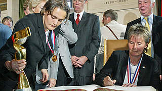 Eintrag ins goldene Buch der Stadt Frankfurt nach dem WM-Titel 2003: Tina Theune (r.) © Bongarts/GettyImages