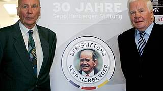 Horst Eckel (l.) und Helmut Haller vor dem Jubiläums-Logo © 